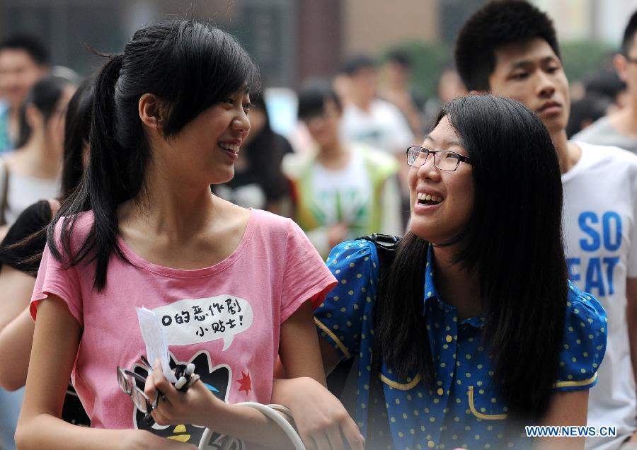 Examinees walk out of the exam site after the first test of the national college entrance exam at the No. 11 Middle School in Zhengzhou, capital of central China's Henan Province, June 7, 2013. Some 9.12 million applicants are expected to sit this year's college entrance exam on June 7 and 8. (Xinhua/Li Bo)