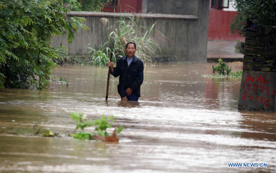 A villager walks in floods in Gangdong Village, Duchang County, east China's Jiangxi Province, June 7, 2013. Heavy rain began to affect Duchang on Thursday and continued into Friday morning, with the average precipitations in excess of 150 mm, and made some houses, roads and fields flooded. (Xinhua/Fu Jianbin) 