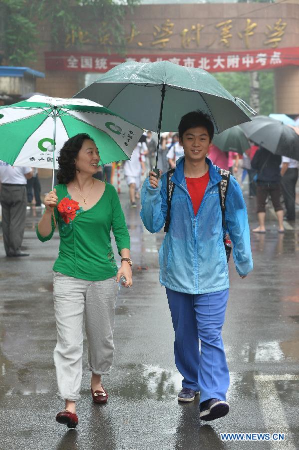 An examinee of the national college entrance exam and his mother leave the exam site at the Affiliated High School of Peking University in Beijing, capital of China, June 7, 2013. Some 9.12 million applicants are expected to sit this year's college entrance exam on June 7 and 8. (Xinhua/Li Xin)