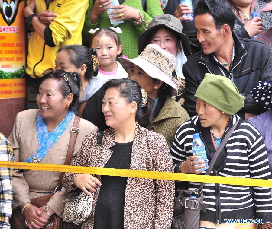 Parents wait outside the exam site as their children taking the national college entrance exam at the Lhasa Middle School in Lhasa, capital of southwest China's Tibet Autonomous Region, June 7, 2013. Some 9.12 million applicants are expected to sit this year's college entrance exam on June 7 and 8. (Xinhua/Liu Kun)