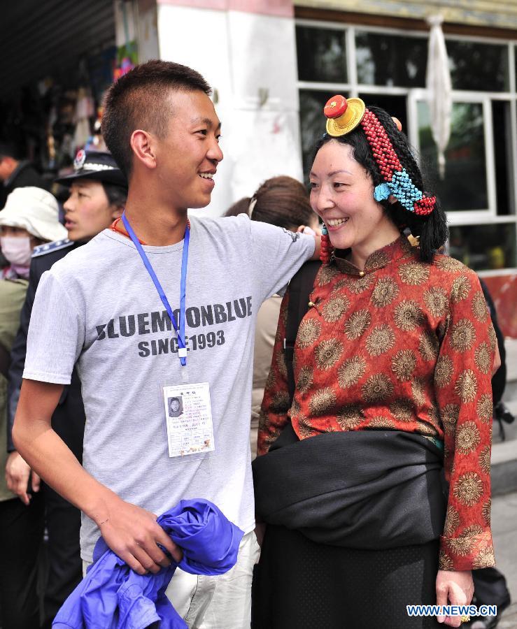 An examinee talks with his mother after taking the first test of the national college entrance exam at the Lhasa Middle School in Lhasa, capital of southwest China's Tibet Autonomous Region, June 7, 2013. Some 9.12 million applicants are expected to sit this year's college entrance exam on June 7 and 8. (Xinhua/Liu Kun)