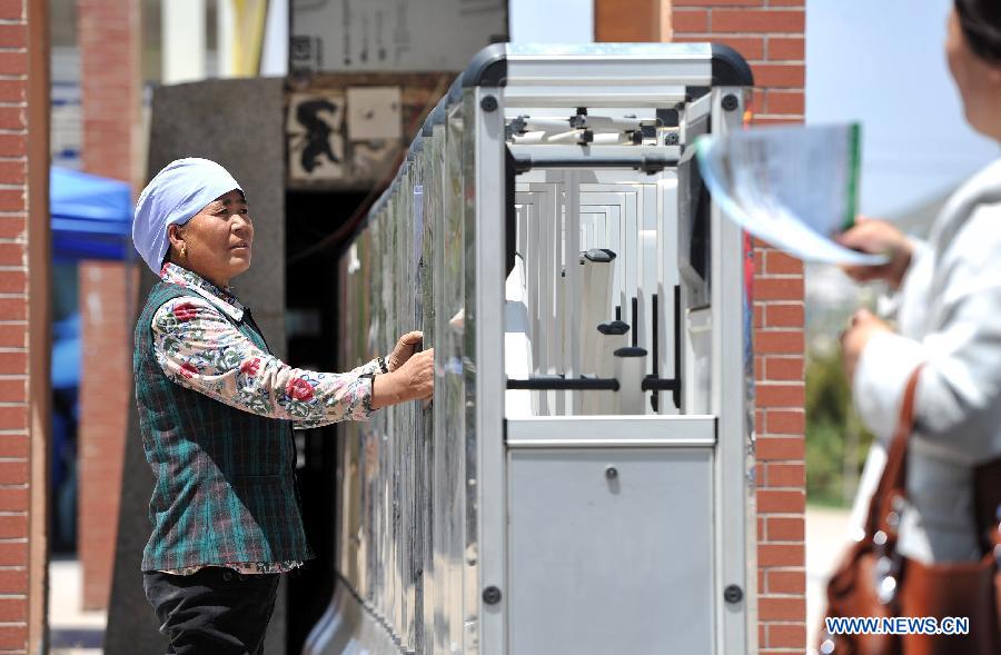 A parent waits outside the exam site as their children taking the national college entrance exam at the Xiji Middle School in Xiji County, northwest China's Ningxia Hui Autonomous Region, June 7, 2013. Some 9.12 million applicants are expected to sit this year's college entrance exam on June 7 and 8. (Xinhua/Peng Zhaozhi)