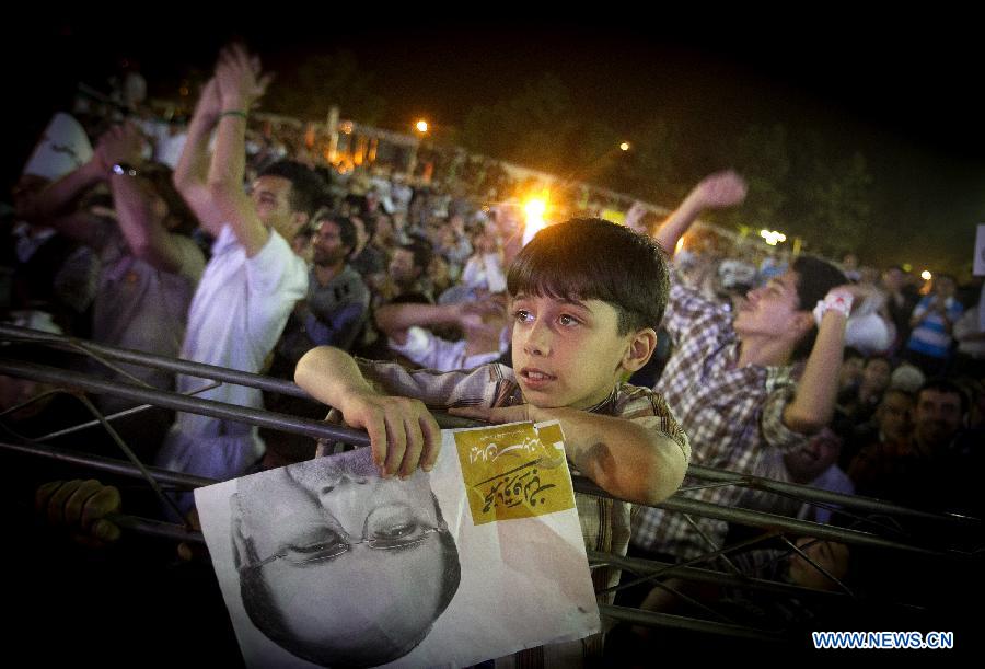 An Iranian boy holds a poster of Tehran Mayor and presidential candidate Mohammad-Baqer Qalibaf during a campaign rally in Shahr-e Rey, south of Tehran, Iran, on June 7, 2013. Iran's 11th presidential election is scheduled for June 14. (Xinhua/Ahmad Halabisaz) 