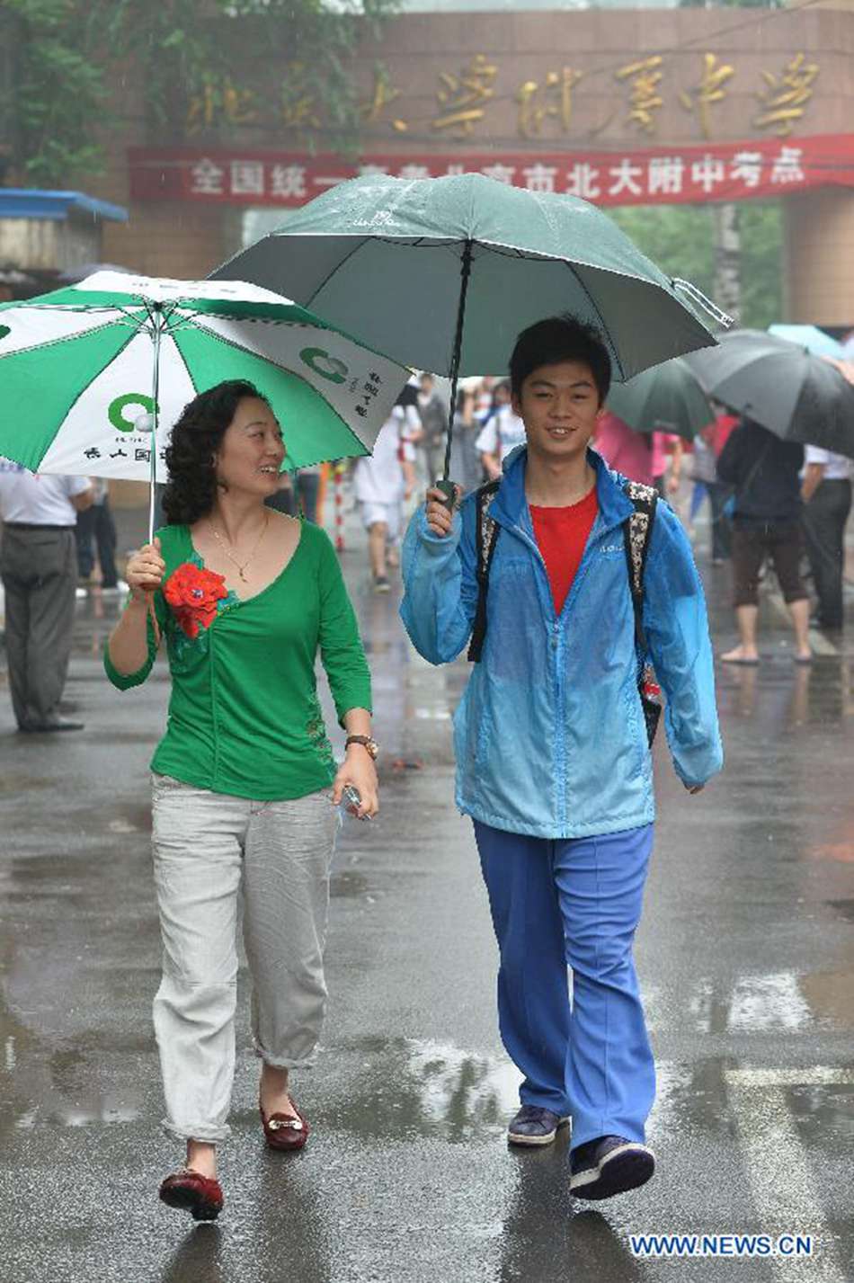 An examinee of the national college entrance exam and his mother leave the exam site at the Affiliated High School of Peking University in Beijing, capital of China, June 7, 2013. Some 9.12 million applicants are expected to sit this year's college entrance exam on June 7 and 8. 