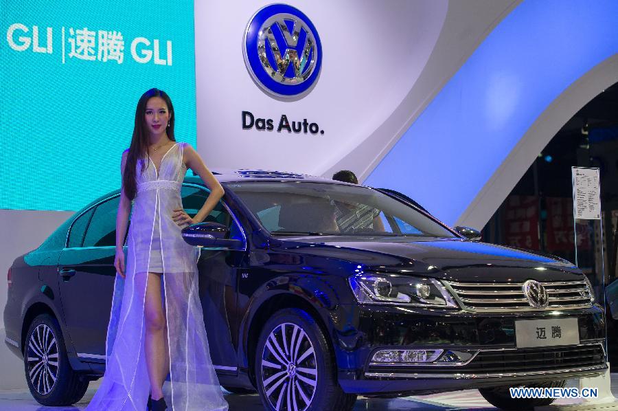 A model poses beside a car at the 15th Chongqing International Auto Industry Fair in Chongqing, southwest China's municipality, June 7, 2013. Opened Friday, the week-long fair attracts 105 domestic and foreign exhibitors and will launch 60 new models. (Xinhua/Chen Cheng)