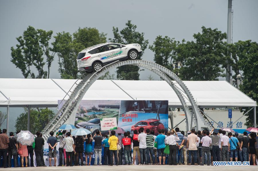 A car stunt show is seen at the 15th Chongqing International Auto Industry Fair in Chongqing, southwest China's municipality, June 7, 2013. Opened Friday, the week-long fair attracts 105 domestic and foreign exhibitors and will launch 60 new models. (Xinhua/Chen Cheng)