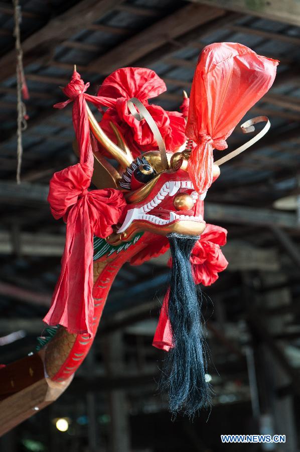 Photo taken on June 6, 2013 shows the decorated bow of a new dragon boat before its launching ceremony at the Chenhanhui Shipyard at Shangjiao village in Guangzhou, capital of South China's Guangdong province. Chenhanhui Shipyard has been busy making new dragon boats and renovating old ones for the upcoming Dragon Boat Festival that falls on June 12 this year. People in many parts of China have the tradition to hold dragon boat races during the festival. (Photo/Xinhua)