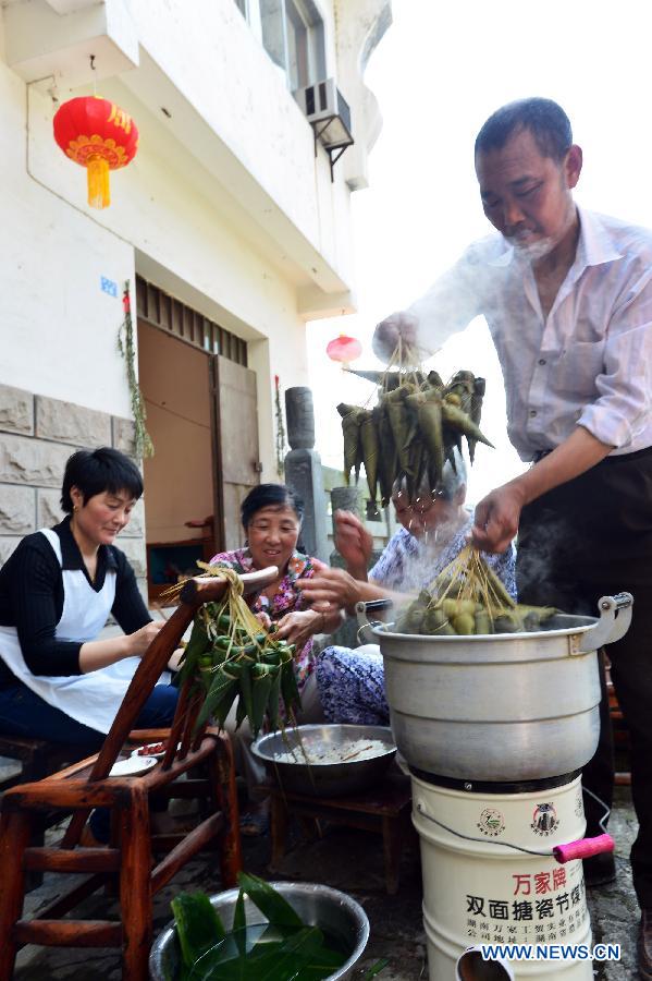 Local residents make Zongzi, some kind of traditional Chinese rice-pudding, at Guizhou Township in Zigui County, cental China's Hubei Province, June 7, 2013. People in Zigui, the hometown of Qu Yuan, prepare to celebrate the upcoming Dragon Boat Festival, or Duanwu Festival, which falls on the fifth day of the fifth month in the Chinese lunar calendar, or June 12 this year. The festival is to commemorate the death of Qu Yuan, a patriot poet during the Warring States Period (475-221B.C.), who committed suicide by flinging himself into the Miluo River after his mother kingdom, fell into enemy's hands. (Xinhua/Zheng Jiayu)