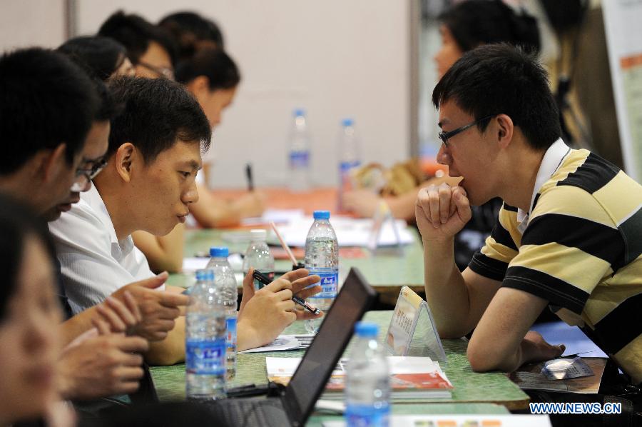 A student takes an interview at a job fair in Hangzhou, capital of east China's Zhejiang Province, June 8, 2013. The job fair offered over 25,000 job posts to college graduates. (Xinhua/Ju Huanzong)