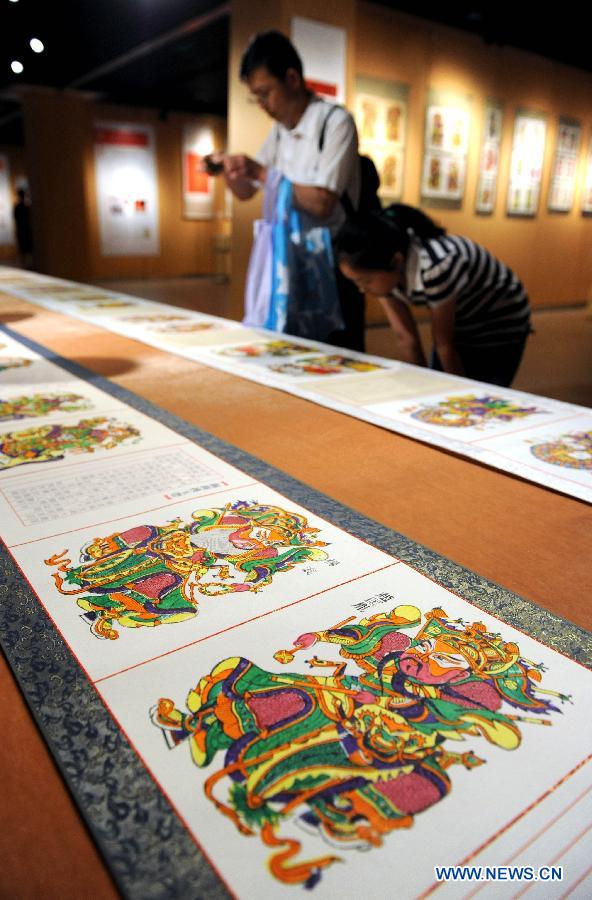 Visitors look at xylograph paintings at an exhibition of intangible cultural heritages in the Henan Museum in Zhengzhou, capital of central China's Henan Province, June 8, 2013. The exhibition was held to mark the 8th National Cultural Heritage Day. (Xinhua/Li Bo) 