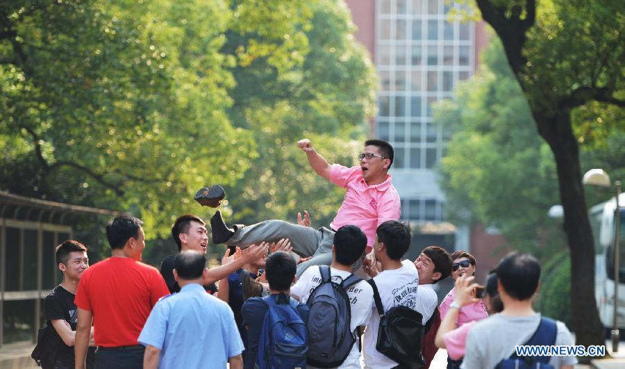 Students toss their teacher after the college entrance examination in the No. 1 Middle School in Changsha, capital of central China's Hunan Province, June 8, 2013. The 2013 national college entrance examination ended in some regions of China on Saturday. Approximately 9.12 million people took part in the exam this year. (Xinhua/Bai Yu) 