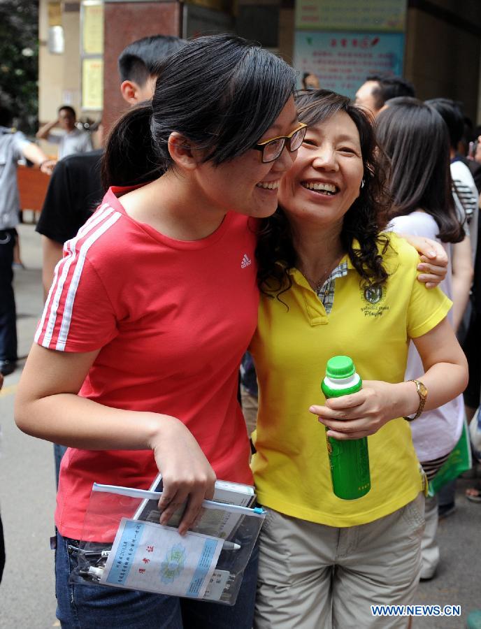 A student (L) hugs a relative of hers after the college entrance examination in Huimin Middle School in Zhengzhou, capital of central China's Henan Province, June 8, 2013. The 2013 national college entrance examination ended in some regions of China on Saturday. Approximately 9.12 million people took part in the exam this year. (Xinhua/Li Bo)