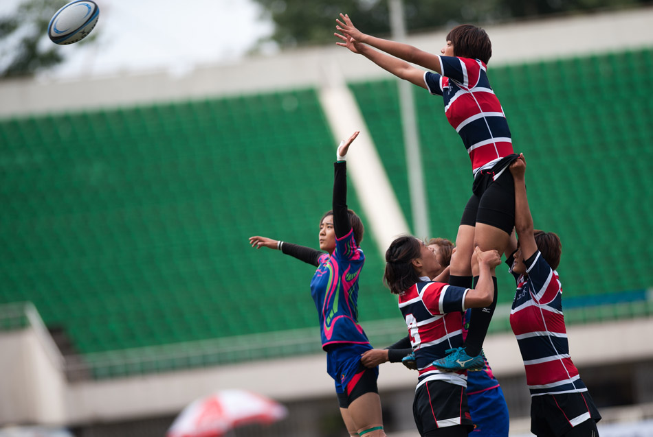 Jiangsu team (in red and blue uniforms) defeats Anhui 19-0 in the preliminary of the women's rugby games of the 12th National Games on June 1, 2013 in Beijing.