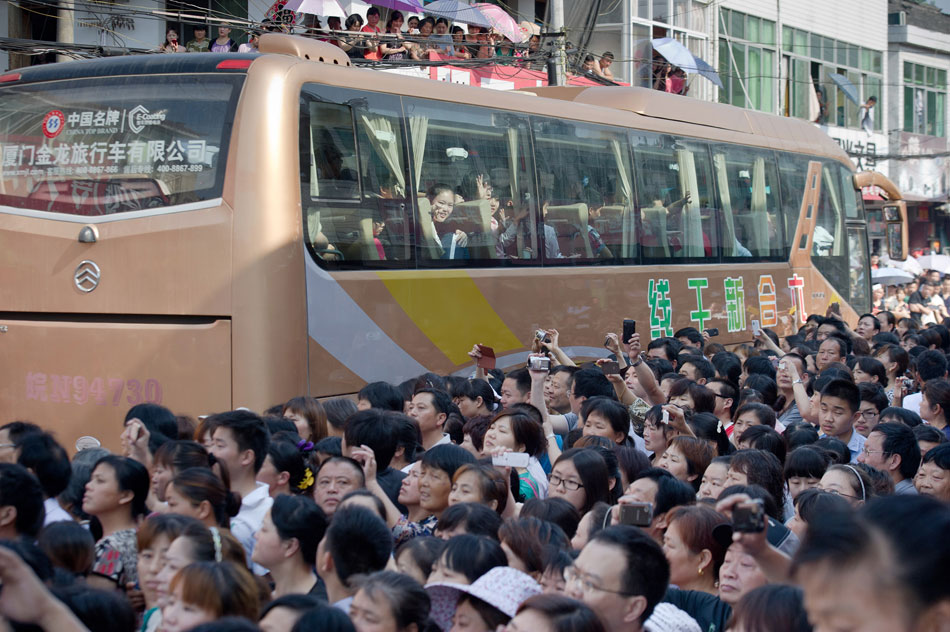 Coaches full of students move slowly in the crowd on June 5, 2013. On this day, over 11,000 students from Maotanchang High School and Jin'an High School in Maotan town, Liu'an, Anhui province left for the university entrance exam places in Liu'an.(Photo/Xinhua)