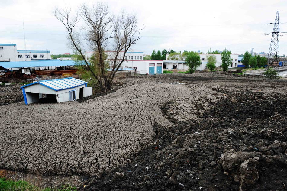 The sludge has "swallowed" half of a makeshift house in Wenchang sewage treatment plant in Harbin, northeast China's Heilongjiang province on May. 20, 2013. (Xinhua/Wang Jianwei)