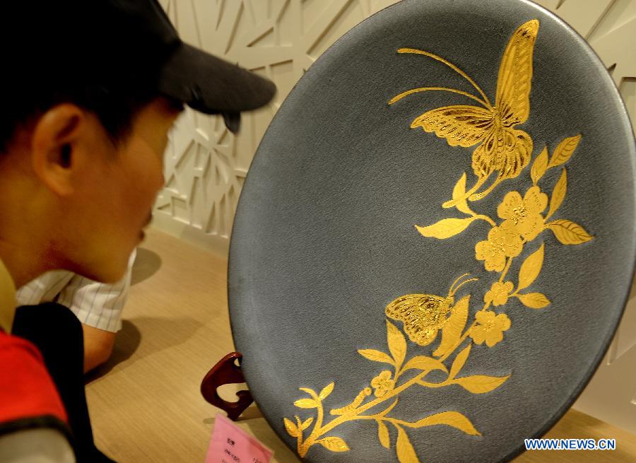 A visitor looks at a ceramic artwork in the town of Yingge of Xinbei City in southeast China's Taiwan, June 8, 2013. Over 100 artists have set up workshops in Yingge, which is famous for ceramics production, providing opportunities for visitors to experience the process of making porcelains. (Xinhua/Tao Ming) 