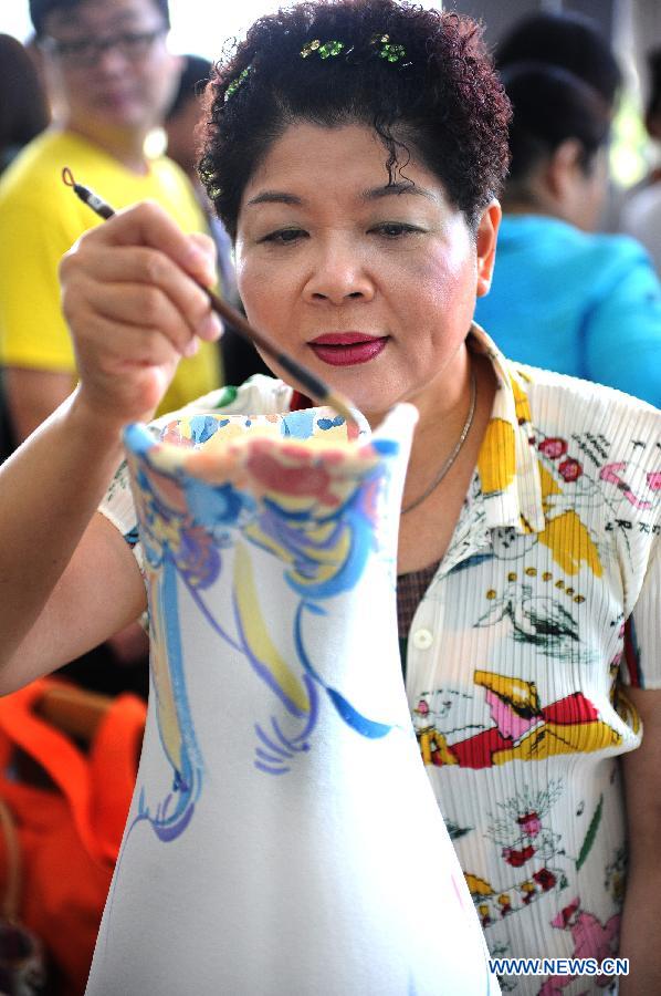 An artist paints on a porcelain vase in the town of Yingge of Xinbei City in southeast China's Taiwan, June 8, 2013. Over 100 artists have set up workshops in Yingge, which is famous for ceramics production, providing opportunities for visitors to experience the process of making porcelains. (Xinhua/Tao Ming) 