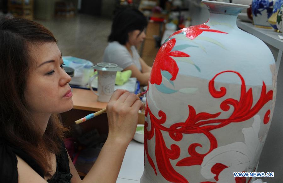Artists paint on porcelain vases in the town of Yingge of Xinbei City in southeast China's Taiwan, June 8, 2013. Over 100 artists have set up workshops in Yingge, which is famous for ceramics production, providing opportunities for visitors to experience the process of making porcelains. (Xinhua/Tao Ming) 