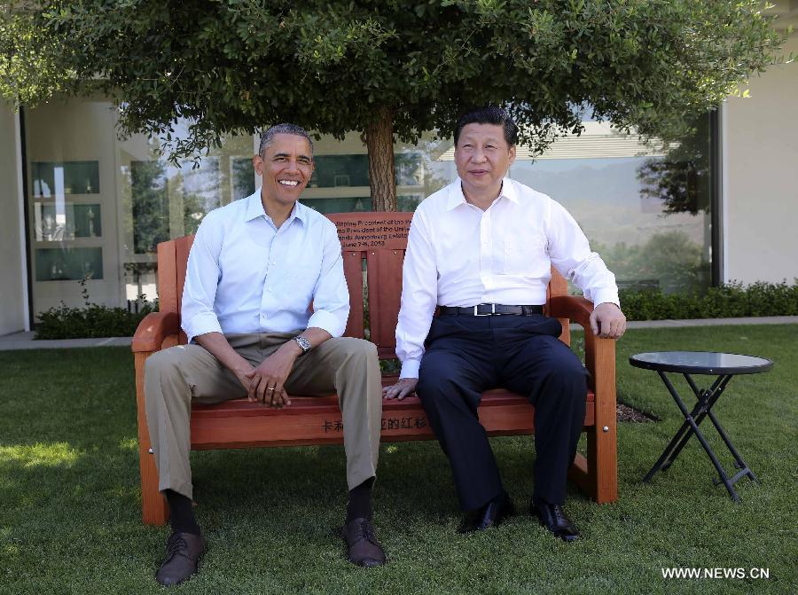 U.S. President Barack Obama (L) presents Chinese President Xi Jinping with a bench made of California redwood while they take a joint walk before heading into their second meeting, at the Annenberg Retreat, California, the United States, June 8, 2013. Chinese President Xi Jinping and U.S. President Barack Obama held the second meeting here on Saturday to exchange views on economic ties. (Xinhua/Lan Hongguang) 