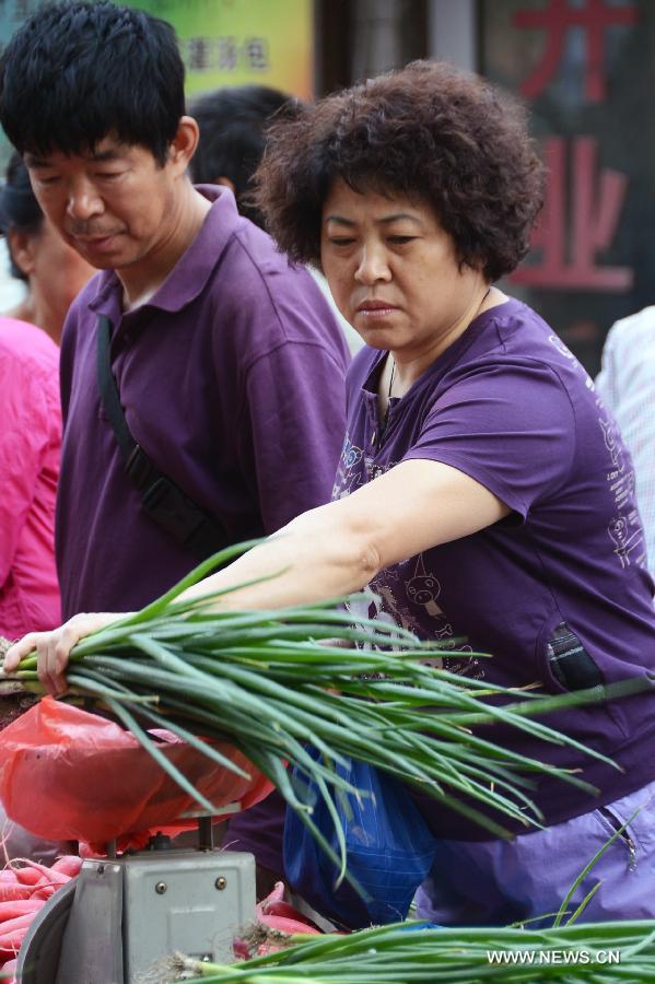 A woman chooses vegetables in a market in Changchun, capital of northeast China's Jilin Province, June 9, 2013. China's consumer price index (CPI), a main gauge of inflation, grew 2.1 percent year on year in May, down from 2.4 percent in April, the National Bureau of Statistics said on Sunday. (Xinhua/Lin Hong)