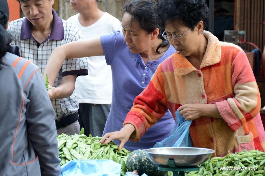 People choose vegetables in a market in Changchun, capital of northeast China's Jilin Province, June 9, 2013. China's consumer price index (CPI), a main gauge of inflation, grew 2.1 percent year on year in May, down from 2.4 percent in April, the National Bureau of Statistics said on Sunday. (Xinhua/Lin Hong)