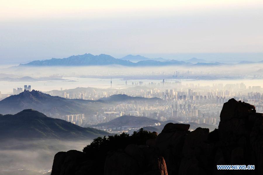 Photo taken from the top of Laoshan Mountain shows the fog-shrouded Qingdao City during the early evening in east China's Shandong Province, June 1, 2013. (Xinhua/Yuan Chungang) 