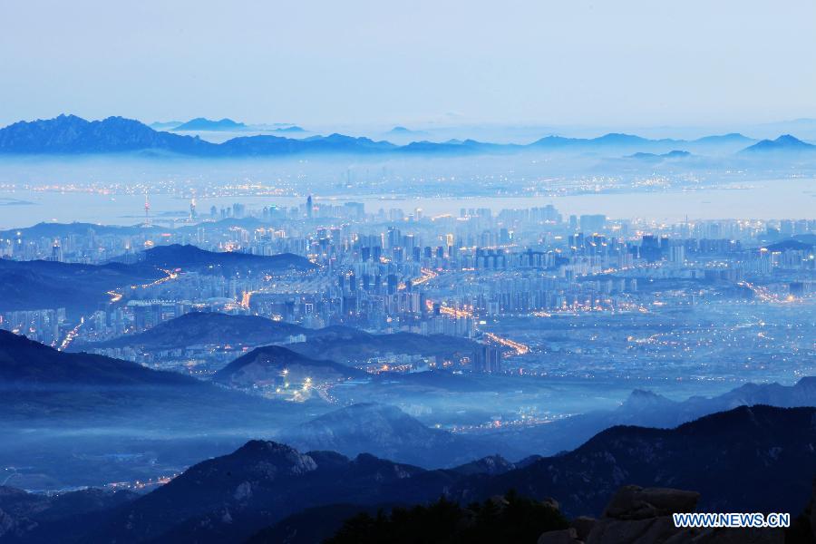 Photo taken from the top of Laoshan Mountain shows the fog-shrouded Qingdao City during the early evening in east China's Shandong Province, June 1, 2013. (Xinhua/Yuan Chungang)