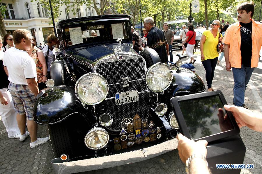 Visitors gather around a classic old-timer car during a grand exhibition of the classic vintage cars, on the Kurfuerstendamm Avenue, in Berlin, Germany, June 8, 2013. Some 2,000 well-preserved and well-functioning classic vintage cars and limousines at least over 50-year-old are exhibited at the fair, with the motto "when luxury meets classics". (Xinhua/Pan Xu) 