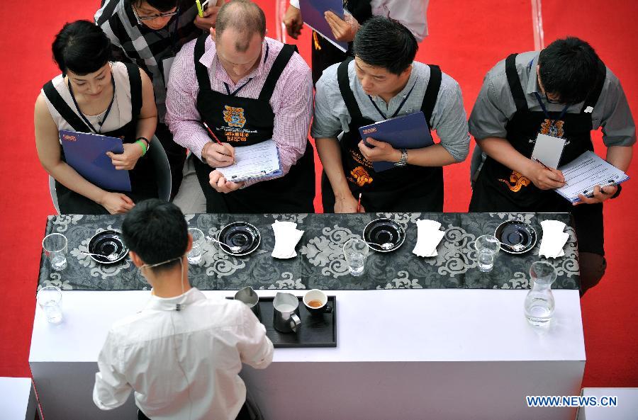 Judges watch a barista making a coffee in the 2nd Fushan Cup international Barista Championship of China in Chengmai, south China's Hainan Province, June 9, 2013. A total of 24 baristas around the world participated in the championship. (Xinhua/Guo Cheng)