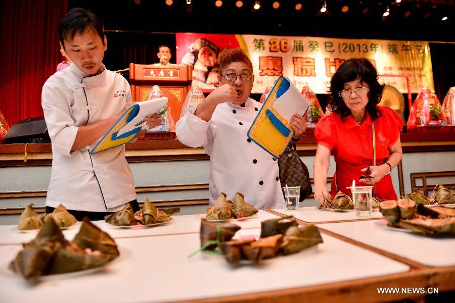 Judges try out and give marks to Zongzi, a pyramid-shaped dumpling made of glutinous rice wrapped in bamboo or reed leaves, during a contest in celebration of the upcoming Dragon Boat Festival in Kuala Lumpur, Malaysia, June 9, 2013. The contest was held by a local Chinese association to promote the traditional Chinese festival -- Dragon Boat Festival, which falls on the fifth day on the fifth month on the lunar calendar. (Xinhua/Chong Voon Chung)