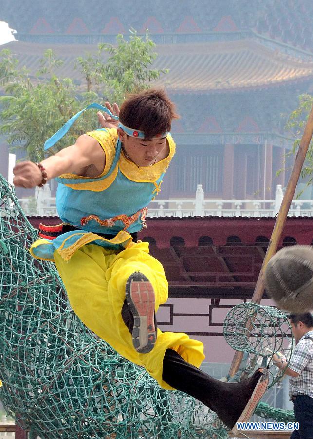 An actor plays Cuju, an ancient form of soccer, during a performance on the Cultral Week for the annual Dragon Boat Festival in Kaifeng, central China's Henan Province, June 9, 2013. The week-long event, which was kicked off here Sunday, will held a series of activities of folk custom, showcasing local intangible cultural heritage to tourists. (Xinhua/Wang Song)