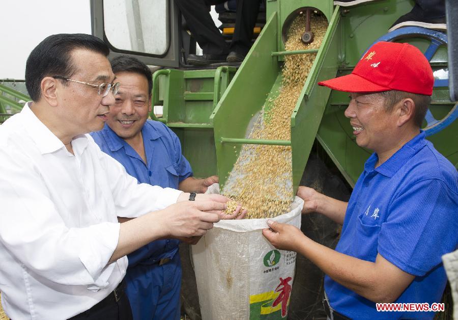 Chinese Premier Li Keqiang (L), also a member of the Standing Committee of the Political Bureau of the Communist Party of China Central Committee, talks with a worker for wheat harvest in Peibao East Village of Handan County, north China's Hebei Province, June 7, 2013. Li paid an inspection tour to Hebei Province from June 7 to 8. (Xinhua/Huang Jingwen)