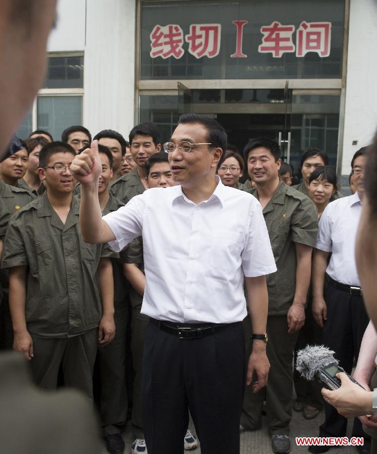 Chinese Premier Li Keqiang (front), also a member of the Standing Committee of the Political Bureau of the Communist Party of China Central Committee, visits a photovoltaic enterprise in Xingtai, north China's Hebei Province, June 7, 2013. Li paid an inspection tour to Hebei Province from June 7 to 8. (Xinhua/Huang Jingwen)