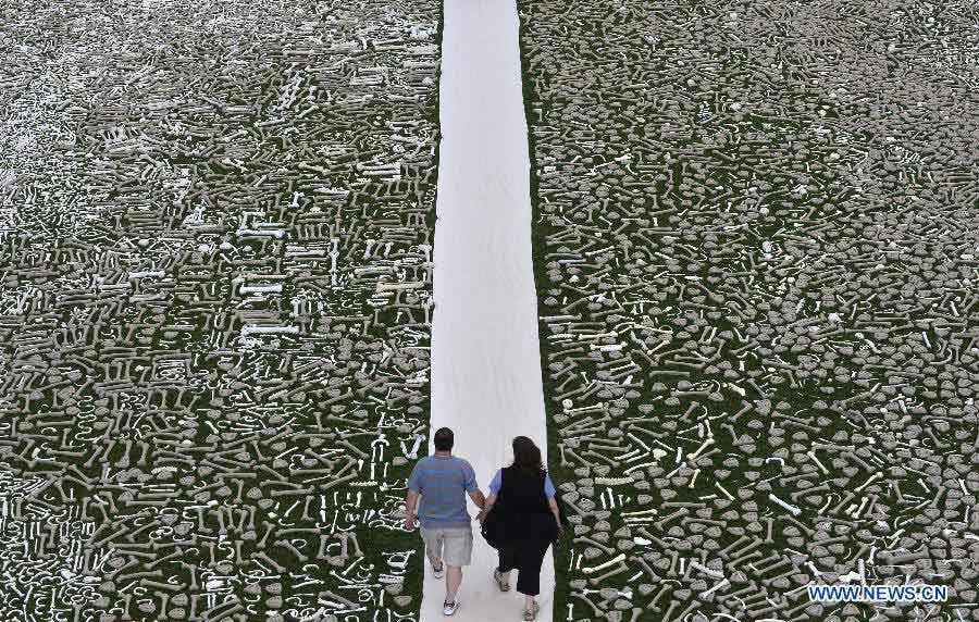 Visitors walk among bones during a demonstration named "One Million Bones" on the National Mall in Washington D.C., capital of the United States, June 9, 2013. One million handmade human bones, created by students, artists, and activists were laid during the weekend on the National Mall as a symbolic mass grave and a visible petition to end genocide and mass atrocities. (Xinhua/Zhang Jun) 