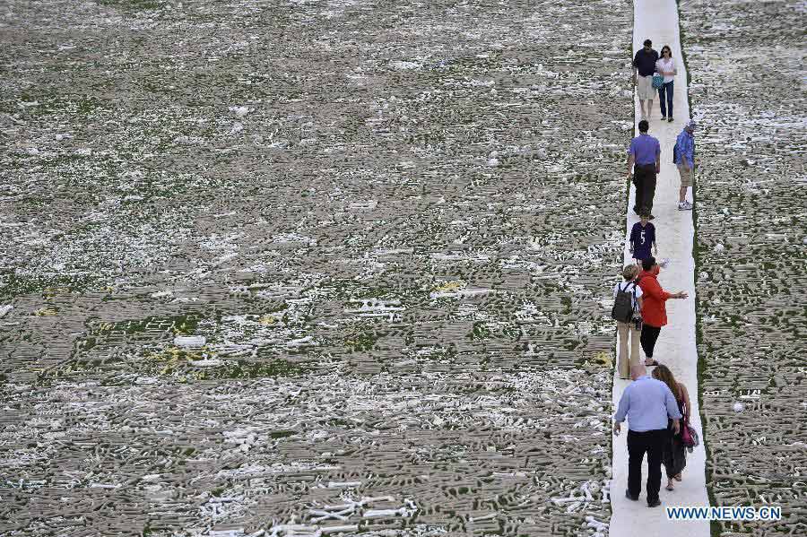 Visitors walk among bones during a demonstration named "One Million Bones" on the National Mall in Washington D.C., capital of the United States, June 9, 2013. One million handmade human bones, created by students, artists, and activists were laid during the weekend on the National Mall as a symbolic mass grave and a visible petition to end genocide and mass atrocities. (Xinhua/Zhang Jun) 