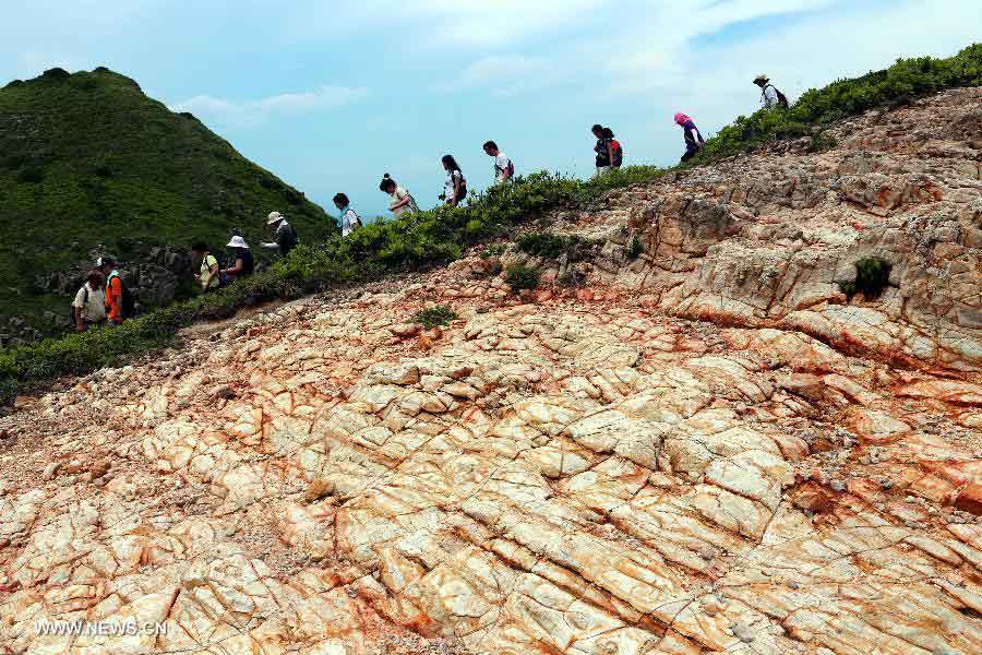 Tourists walk past spotted stone on the South Ninepin Island in Hong Kong, south China, June 9, 2013. The Ninepin Group, or Kwo Chau Islands, is a group of islands in the southeastern Hong Kong. (Xinhua/Li Peng) 