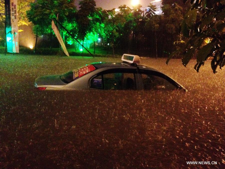 A taxi is submerged in the flood water at a community in Nanning City, capital of south China's Guangxi Zhuang Autonomous Region June 9, 2013. A thunder storm hit Nanning Sunday night, causing floods in many regions of the city. (Xinhua/Xiang Zhiqiang) 
