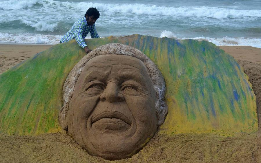 Sand artist Sudarshan Pattnaik gives a final touch to his sand sculpture of former South African President Nelson Mandela on the beach of Puri in eastern Indian state Orissa's Bhubaneswar, June 9, 2013. There is no update on the condition of South Africa's anti-apartheid hero Nelson Mandela, who spent his second day in hospital on Sunday since admitted for a recurring lung infection. (Xinhua/Stringer) 