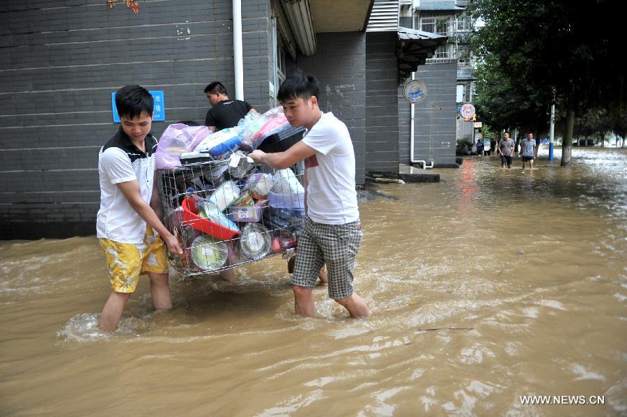 Citizens evacuate their belongings on a flooded road in Liuzhou City, south China's Guangxi Zhuang Autonomous Region, June 10, 2013. Lingering heavy rainfalls in recent days has caused the Liujiang River's water level to rise to 82.7 meters in urban Liuzhou by 11 a.m. Beijing Time (0300 GMT) on Monday, 0.2 meters higher than the warning level. (Xinhua/Li Hanchi) 
