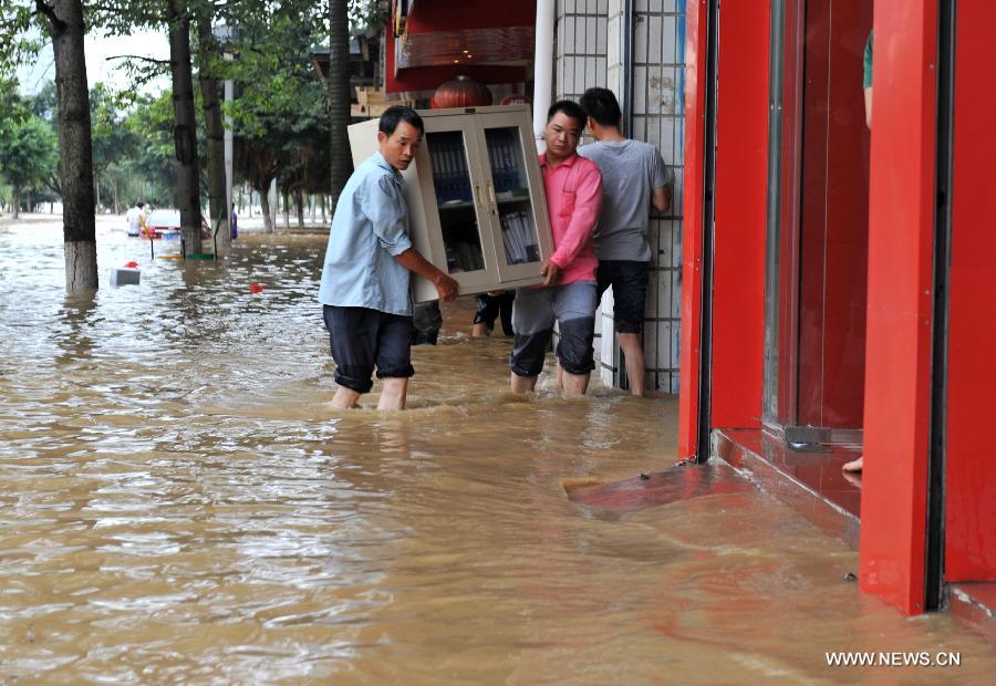 Citizens evacuate their belongings on a flooded road in Liuzhou City, south China's Guangxi Zhuang Autonomous Region, June 10, 2013. Lingering heavy rainfalls in recent days has caused the Liujiang River's water level to rise to 82.7 meters in urban Liuzhou by 11 a.m. Beijing Time (0300 GMT) on Monday, 0.2 meters higher than the warning level. (Xinhua/Li Bin) 