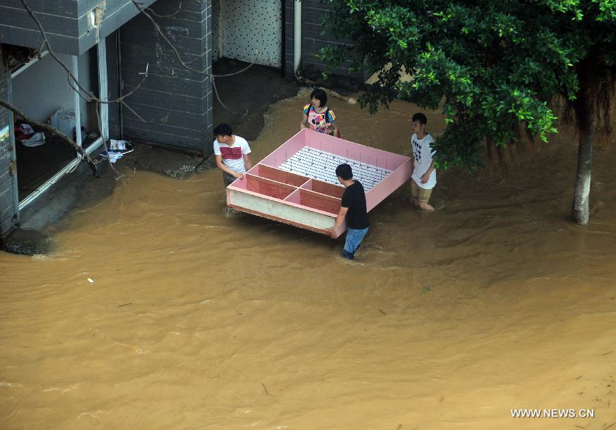 Citizens evacuate their belongings on a flooded road in Liuzhou City, south China's Guangxi Zhuang Autonomous Region, June 10, 2013. Lingering heavy rainfalls in recent days has caused the Liujiang River's water level to rise to 82.7 meters in urban Liuzhou by 11 a.m. Beijing Time (0300 GMT) on Monday, 0.2 meters higher than the warning level. (Xinhua/Huang Xiaobang) 