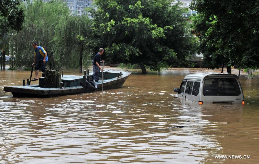 A vehicle is trapped on a flooded road in Liuzhou City, south China's Guangxi Zhuang Autonomous Region, June 10, 2013. Lingering heavy rainfalls in recent days has caused the Liujiang River's water level to rise to 82.7 meters in urban Liuzhou by 11 a.m. Beijing Time (0300 GMT) on Monday, 0.2 meters higher than the warning level. (Xinhua/Li Bin) 