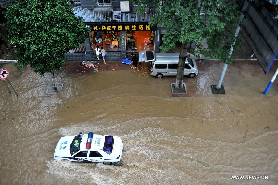 A police vehicle moves on a flooded road in Liuzhou City, south China's Guangxi Zhuang Autonomous Region, June 10, 2013. Lingering heavy rainfalls in recent days has caused the Liujiang River's water level to rise to 82.7 meters in urban Liuzhou by 11 a.m. Beijing Time (0300 GMT) on Monday, 0.2 meters higher than the warning level. (Xinhua/Li Hanchi) 