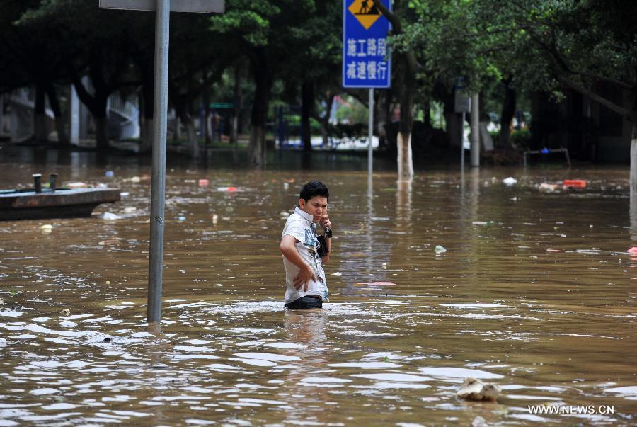 A citizen stands on a flooded road in Liuzhou City, south China's Guangxi Zhuang Autonomous Region, June 10, 2013. Lingering heavy rainfalls in recent days has caused the Liujiang River's water level to rise to 82.7 meters in urban Liuzhou by 11 a.m. Beijing Time (0300 GMT) on Monday, 0.2 meters higher than the warning level. (Xinhua/Li Bin) 