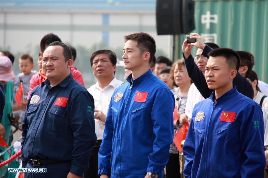 Ye Cong (L), Fu Wentao (C) and Tang Jialing, aquanauts of China's manned submersible "Jiaolong", prepare to leave a port in Jiangyin, east China's Jiangsu province, June 10, 2013, starting a voyage of experimental application of "Jiaolong". During the 103-day mission, the sub will submerge for scientific research in the South China Sea, the northeast Pacific Ocean and the west Pacific. The submersible will for the first time take scientists on board. (Xinhua/Chen Jian)