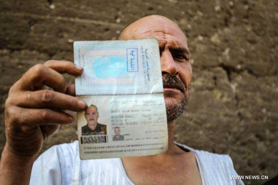Noseir, a Palestinian refugee shows his refugee passport in Fadel Island refugee camp in Sharqia, 90km northeast of Cairo, Egypt, June 10, 2013. Fadel Island village is a forgotten Palestinian refugee camp in Egypt, with about 4,000 Palestinian refugees who came to Eygpt since 1948 living in it. Refugees there are living in very harsh circumstances as the camp lacks of infrastructure, health care, education and jobs. As United Nations Relief and Works Agency for Palestine Refugees in the Near East (UNRWA) does not porvide direct service in Egypt, Egyptian government is alone responsible for these refugees. (Xinhua/Amru Salahuddien)