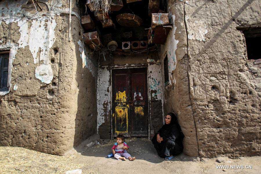 A Palestinian woman sits with her granddaughter in front of her house in Fadel Island refugee camp in Sharqia, 90km northeast of Cairo, Egypt, June 10, 2013. Fadel Island village is a forgotten Palestinian refugee camp in Egypt, with about 4,000 Palestinian refugees who came to Eygpt since 1948 living in it. Refugees there are living in very harsh circumstances as the camp lacks of infrastructure, health care, education and jobs. As United Nations Relief and Works Agency for Palestine Refugees in the Near East (UNRWA) does not porvide direct service in Egypt, Egyptian government is alone responsible for these refugees. (Xinhua/Amru Salahuddien) 