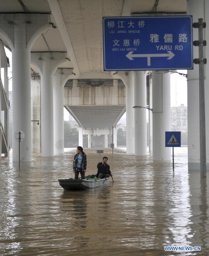 People row on the flood water on Binjiang West Road in Liuzhou City, south China's Guangxi Zhuang Autonomous Region, June 10, 2013. Liujiang River's flood peak of the year appeared in urban Liuzhou on Monday, with its water level reaching 83.71 meters, 1.21 meters higher than the warning line. (Xinhua/Li Hanchi) 
