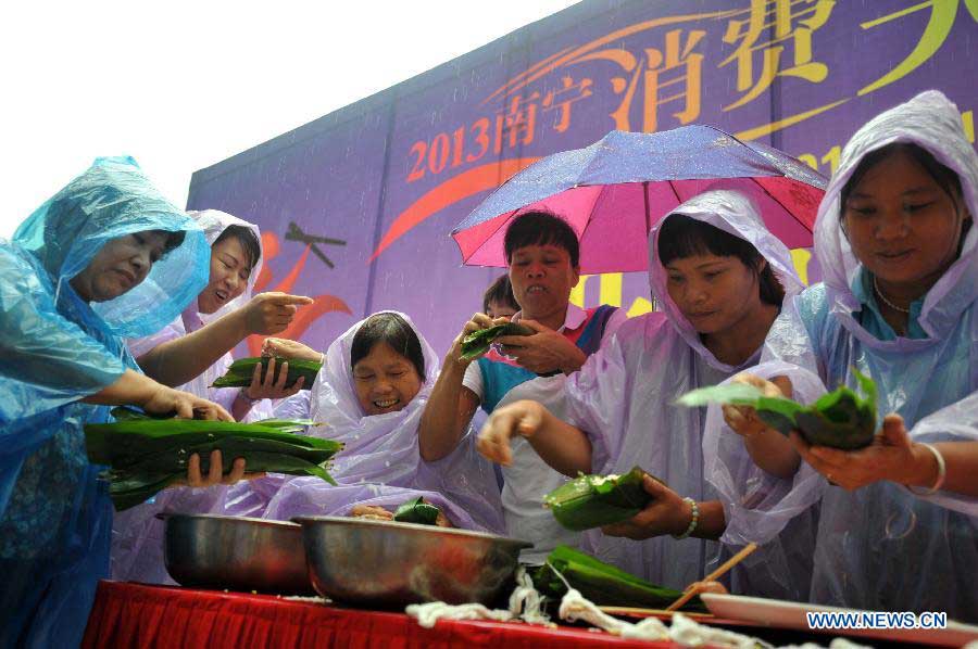 Competitors make zongzi, a pyramid-shaped dumpling made of glutinous rice wrapped in bamboo or reed leaves, at a contest during the Dragon Boat (Duanwu) Festival holiday in Nanning, capital of south China's Guangxi Zhuang Autonomous Region, June 10, 2013. The Duanwu Festival, which is celebrated across China to pay homage to Qu Yuan, a patriotic poet during the Warring State Period (475-221 BC), falls on the fifth day of the fifth month in the Chinese lunar calendar, or June 12 this year. (Xinhua/Lu Bo'an)