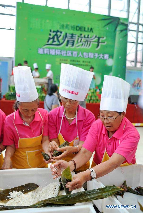 Competitors make zongzi, a pyramid-shaped dumpling made of glutinous rice wrapped in bamboo or reed leaves, at a contest during the Dragon Boat (Duanwu) Festival holiday in Changchun, capital of northeast China's Jilin Province, June 10, 2013. The Duanwu Festival, which is celebrated across China to pay homage to Qu Yuan, a patriotic poet during the Warring State Period (475-221 BC), falls on the fifth day of the fifth month in the Chinese lunar calendar, or June 12 this year. (Xinhua/Zhang Nan) 